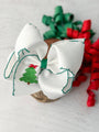White hair bow with Christmas tree design on a light background
