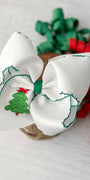 White hair bow with Christmas tree design on a light background