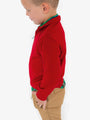 Child wearing a red sweater and beige pants on a white background