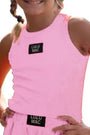 Child wearing a pink tank top and shorts with Lulu Mac branding on a white background