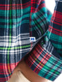Close-up of a plaid fabric with a visible brand logo on a white background