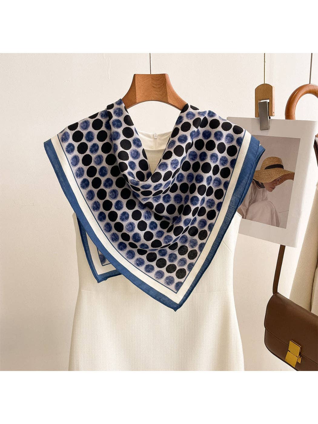 Navy blue dot square scarf wrap with light border, draped at neckline
