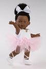 Doll in a ballet outfit with a pink tutu and white shoes on a plain background