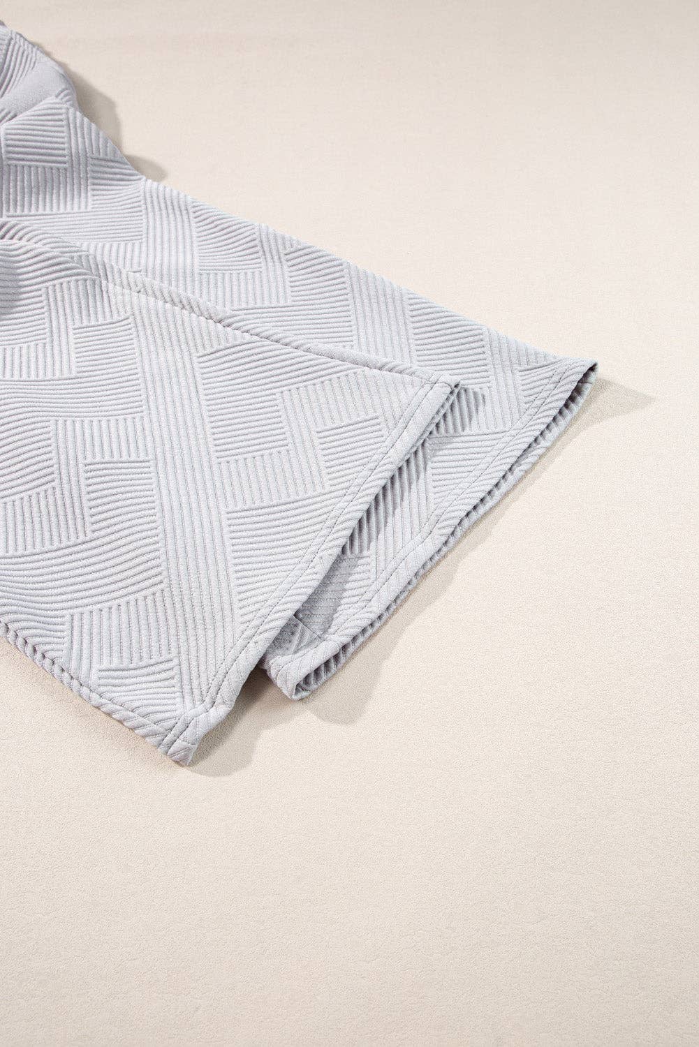 Folded fabric with a geometric pattern on a beige background