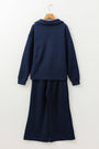 Navy blue outfit with a long-sleeve top and wide-leg pants on a hanger against a white background