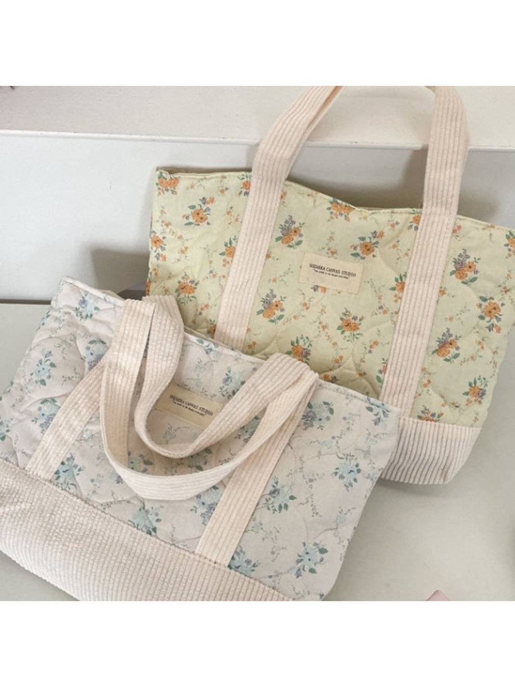 Quilted floral tote bag with cream striped handles and light blue flower print