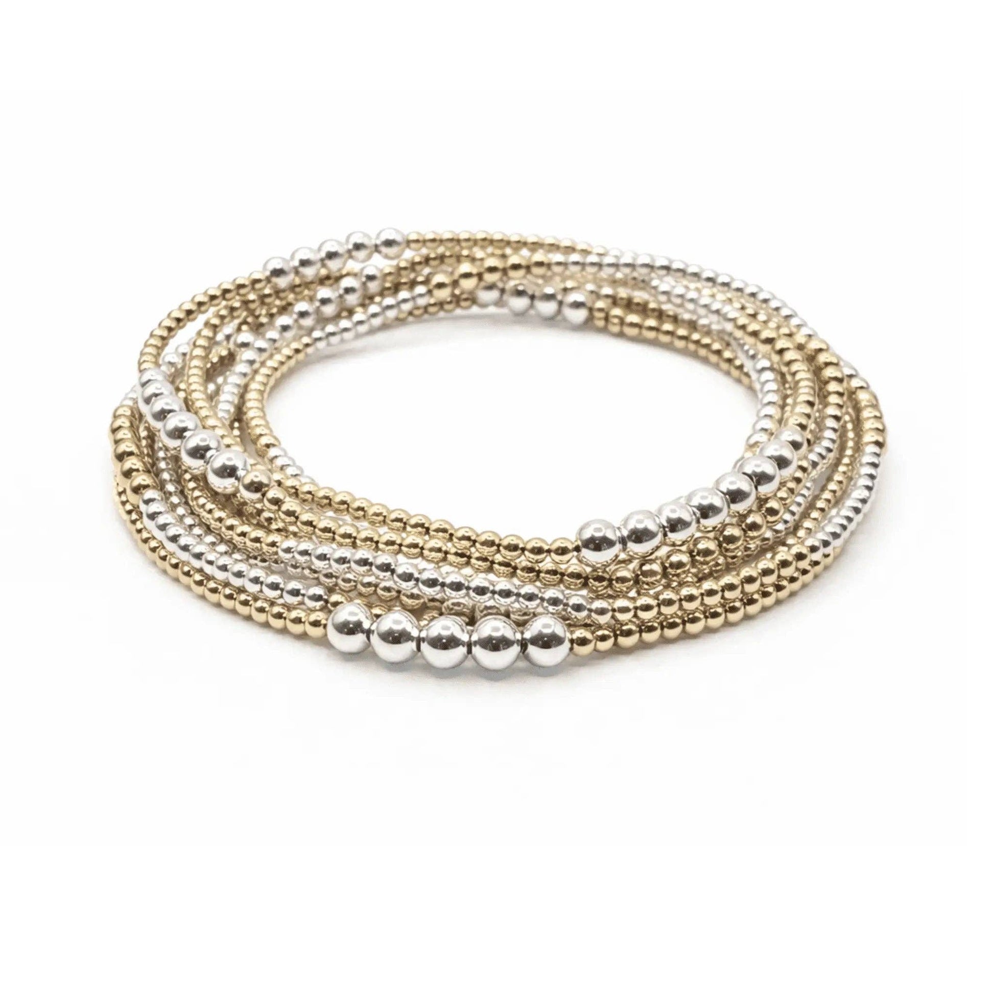 Set of gold and silver beaded bracelets on a white background