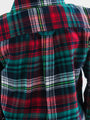 Close-up of a plaid fabric with red, green, and black colors.