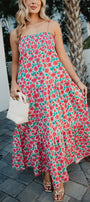 Woman wearing a floral dress walking outdoors.