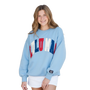 Woman wearing a light blue sweatshirt with colorful text on a white background