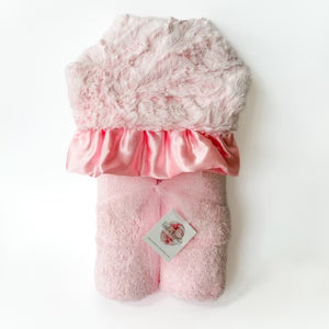 Pink plush toy with a satin bow on a white background