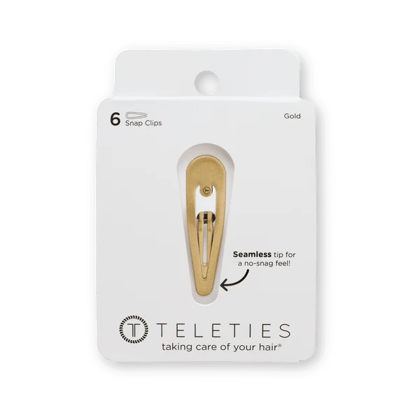 Gold hair clip on a Teleties packaging with text about seamless tip feel.