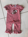 Red and white striped baby romper with a teddy bear design on a tiled floor.
