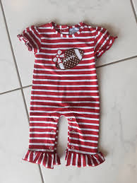 Red and white striped baby romper with a teddy bear design on a tiled floor.