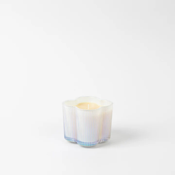 Candle in a decorative glass container on a white background