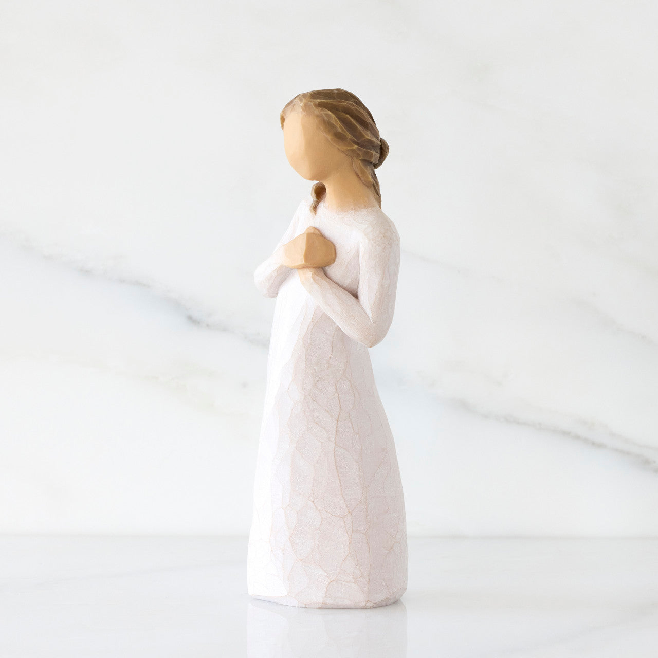 Statue of a woman in a white dress with a plain background