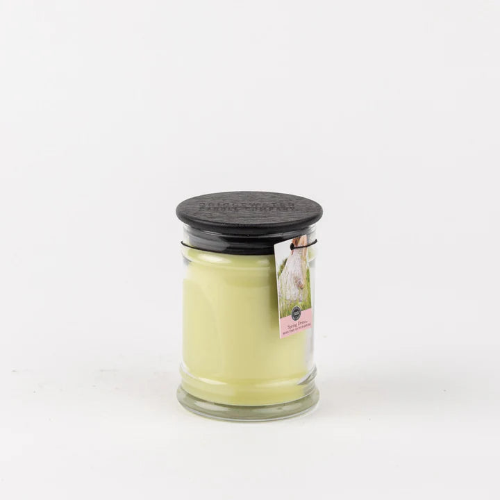 Candle in a glass jar with a black lid on a white background