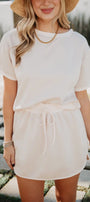 Woman wearing a white outfit with a straw hat in an outdoor setting