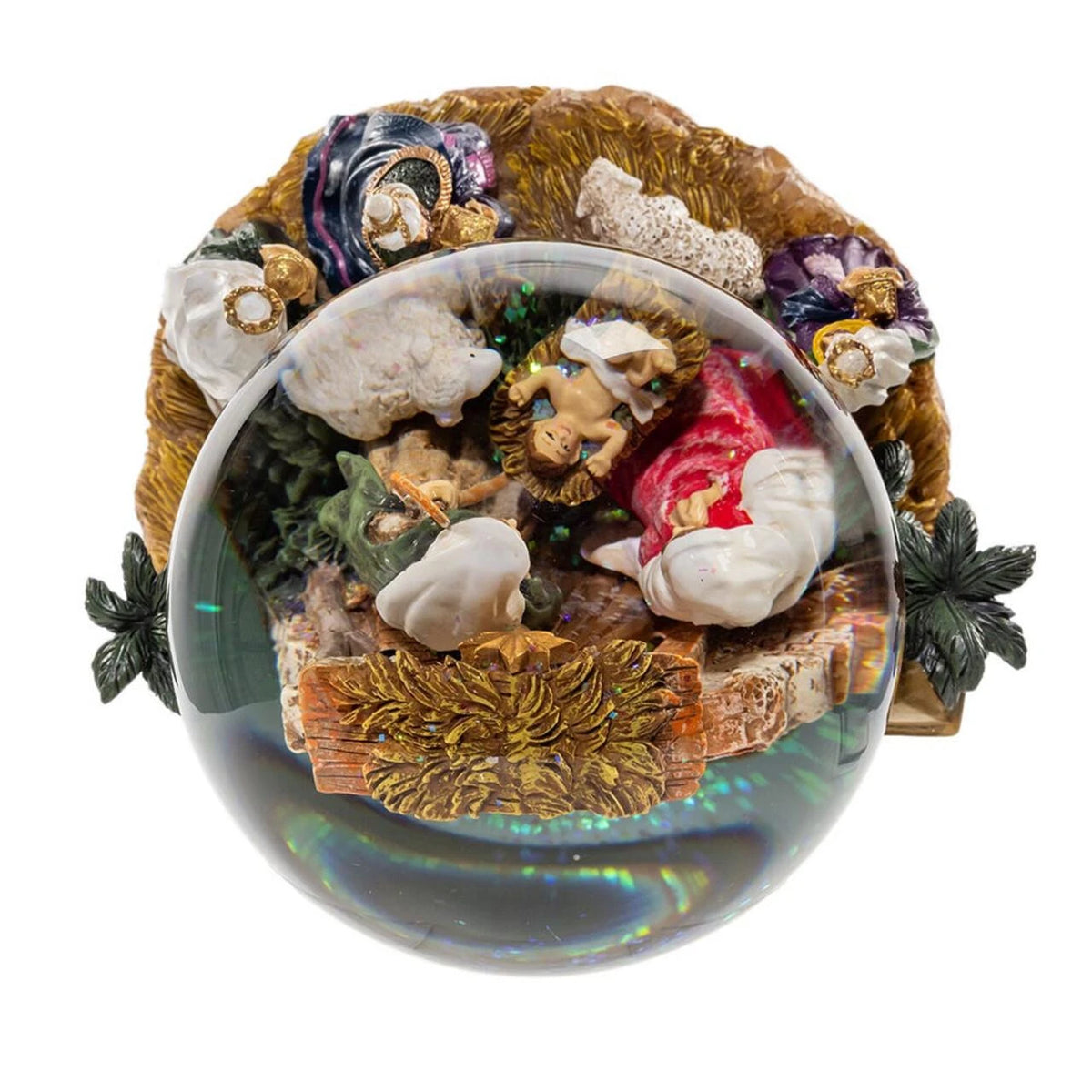 Decorative nativity scene in a glass sphere with figurines and plants on a white background