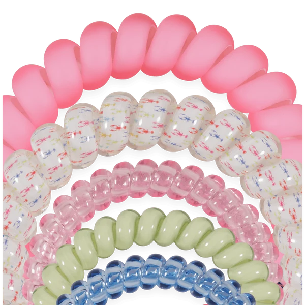 A set of translucent spiral hair elastic bands stacked together, showing multiple colors including pink, white with multicolor flecks, light pink, pale green, and light blue.