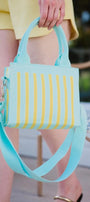 Person holding a striped handbag with a blurred background