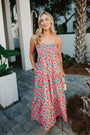 Woman in a floral dress standing outdoors on a patio
