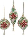 Three Christmas tree ornaments hanging against a white background: one teardrop-shaped ornament in the center and two round ornaments on either side. The ornaments are cream-colored with red and green floral patterns and small bead accents.