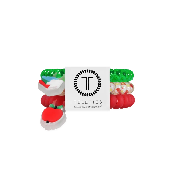 A set of Teleties taking care of your teeth dental toys, featuring red, green, white, and clear silicone pieces arranged behind a white brand card on a solid white background.