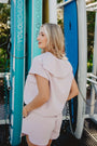 Woman standing in front of Yoloboard surfboards with a blurred outdoor background