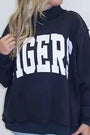 Dark mock neck sweatshirt with large white embroidered letters on the front