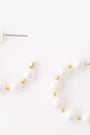 Pair of pearl earrings with gold accents on a white background