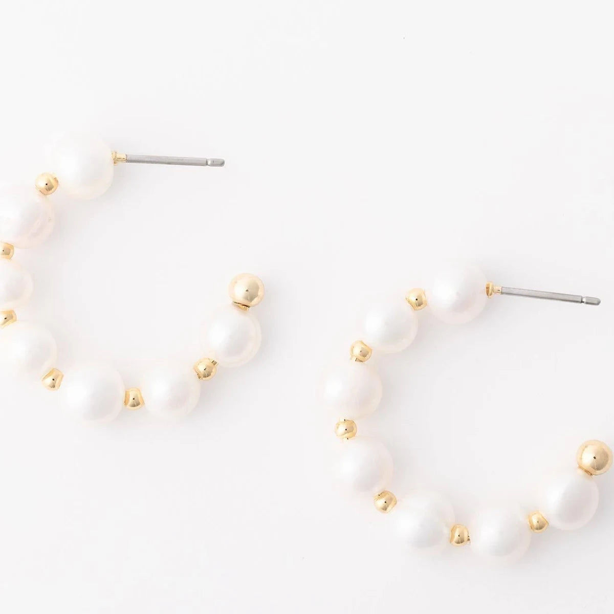 Pair of pearl earrings with gold accents on a white background