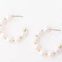 Pair of pearl earrings with gold accents on a white background