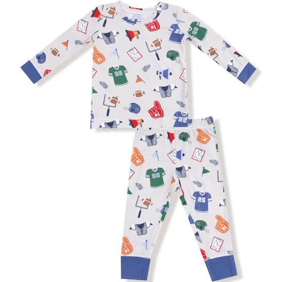 A two-piece children's pajama set featuring a long-sleeve top and matching pants in white with a colorful sports-themed print, including jerseys, footballs, foam fingers, and flags, finished with solid blue cuffs and ankles.