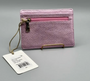 Pink textured wallet with a strap and tag on a gray background