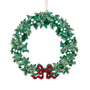 A green holly wreath Christmas ornament with silver glitter accents and a red glitter bow at the bottom, hanging against a plain white background.