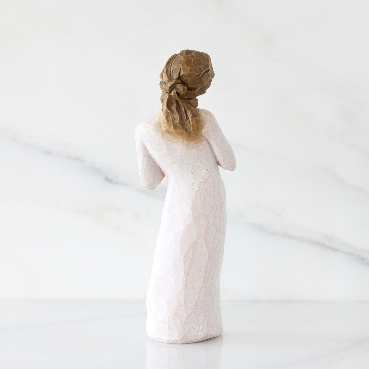 Statue of a woman in a long dress with braided hair on a white background