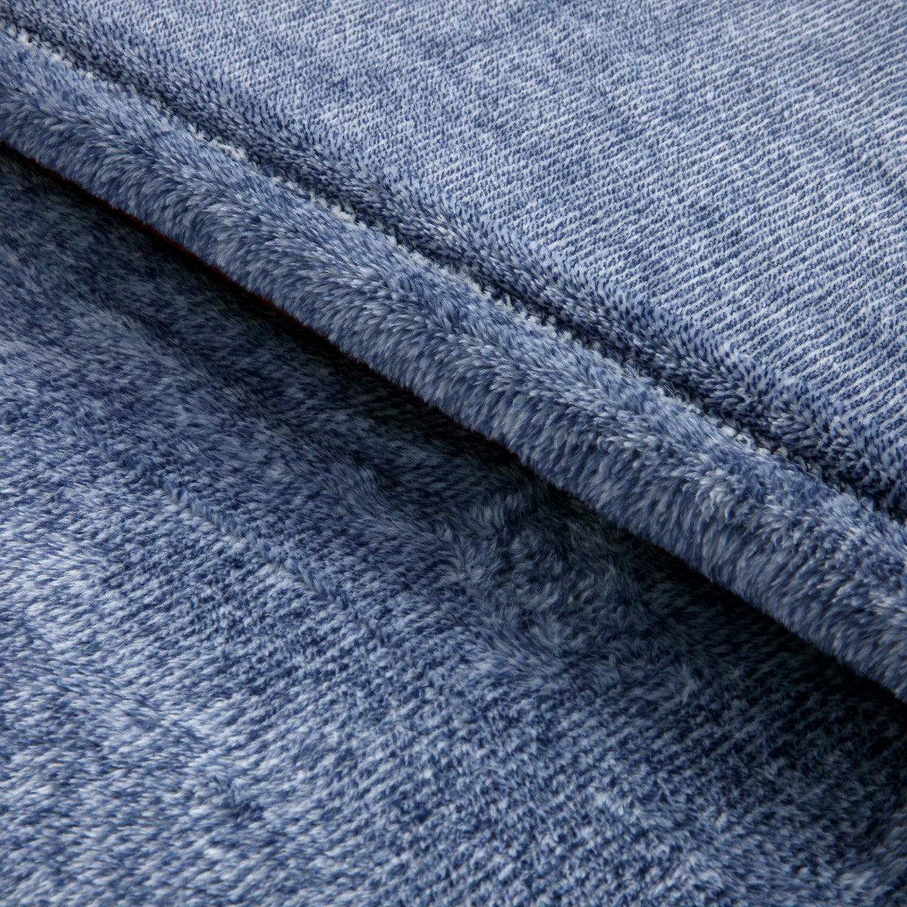 Close-up of blue denim fabric with a visible seam.