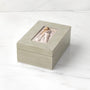 Light gray jewelry box with a mother and daughter hugging on a white background